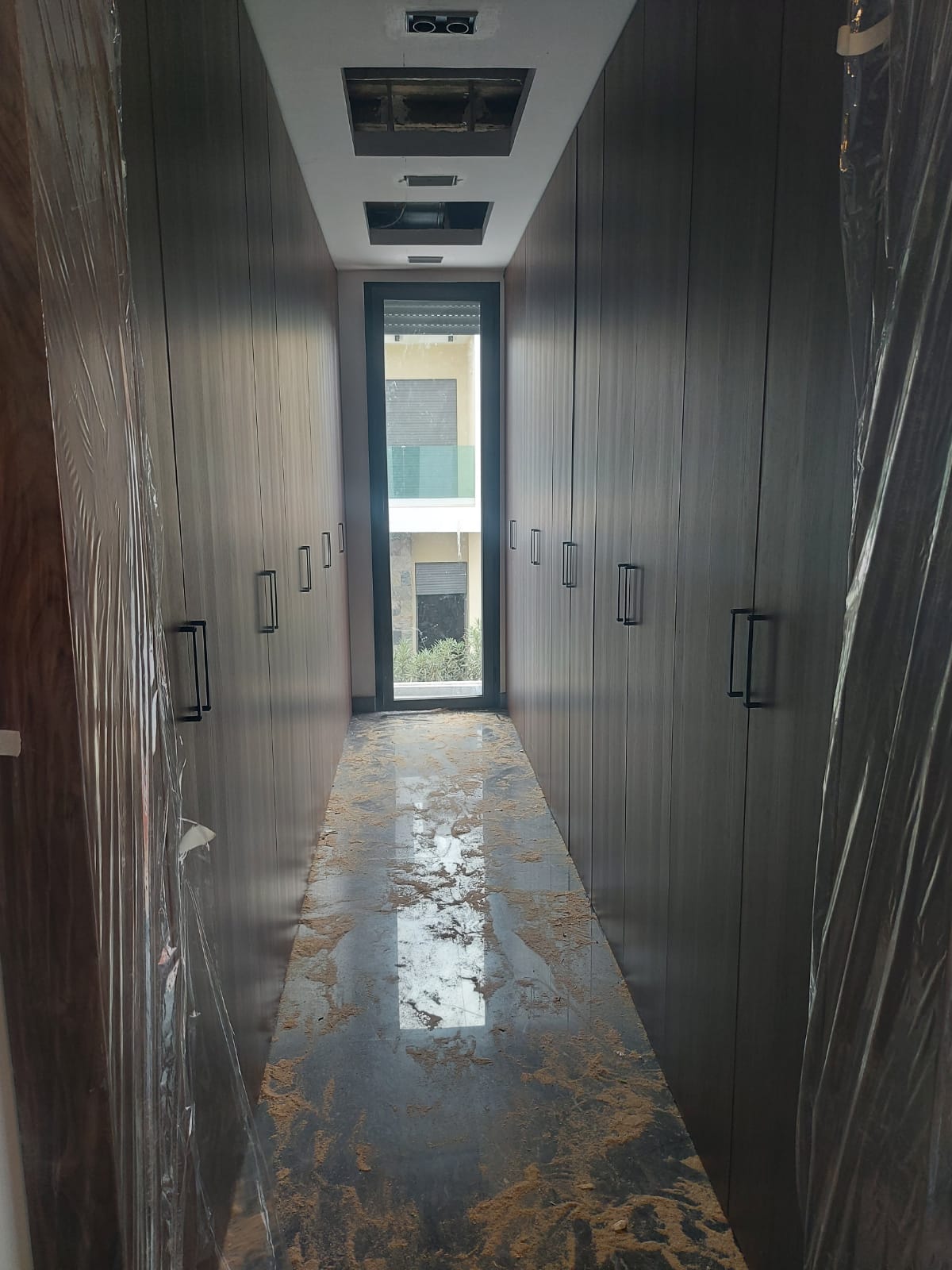 Dressing fermé couloir, façades bois foncé, réalisé par RSS Studio
